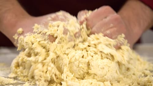 Mann mischt Teig mit den Händen. Baker macht traditionelles Brot oder Kuchen. Bäcker knetet den Teig
.