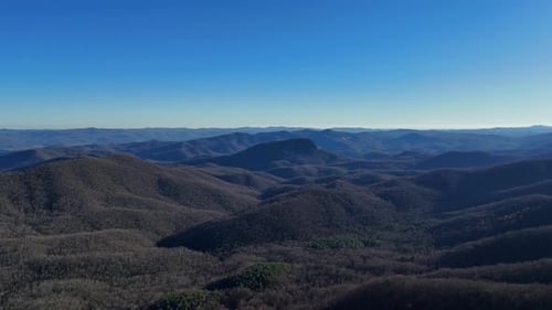 Aerial View of a Valley Surrounded By Mountains on a Sunny Day