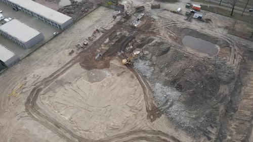 Jib down of excavator collecting rubble from demolished building on construction site