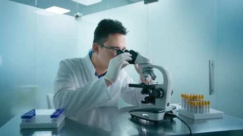 Investigador médico, científico, hombre que observa muestras biológicas bajo el microscopio