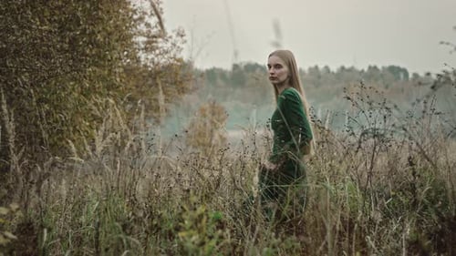 Model posing in flowing green dress outdoors