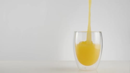 Fresh Orange Juice Pouring Into Modern Glass