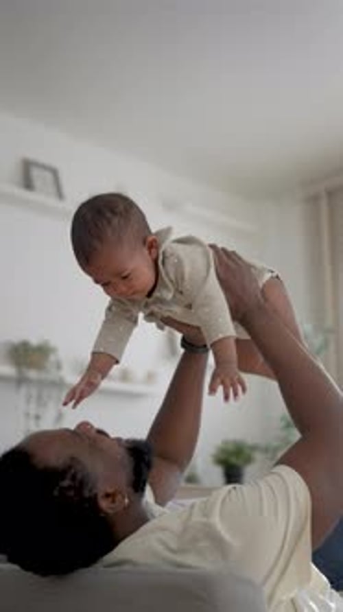 Loving father holding his infant child indoors