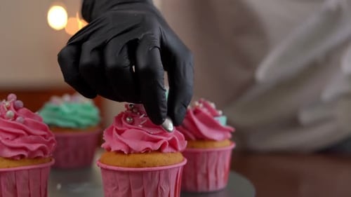 Cupcake Being Decorated With Hearts and Sprinkles