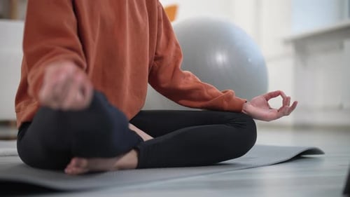 Woman Meditating in Lotus Pose in Home