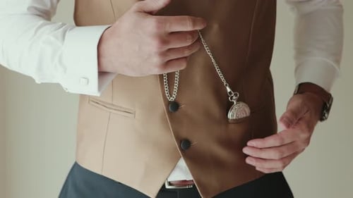Man Adjusts Pocket Watch with Vest and Dress Shirt