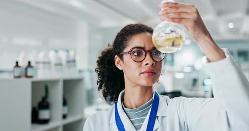 Woman Scientist Examining Flask in Lab