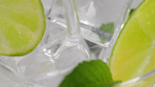 Close Up Of Fresh Lime Soda Being Poured Over Ice Cubes In Glass