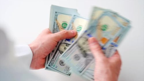 Mains masculines comptant les billets d'un dollar américain en gros plan