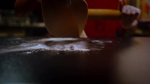Rolling out dough slow motion in a professional kitchen