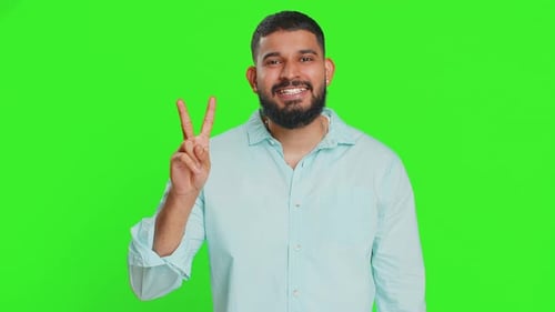 Man Smiling and Making Peace Sign on Green Screen