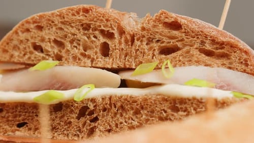 Sándwich escandinavo Smorrebroad con pepinillos de arenque y cebolla sobre escritorio de madera Closeup Holland