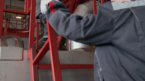 Two Workwoman Climbing Stairs of Machine Platform in Metalworking Shop