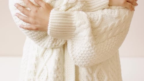 Handberührender warmer, flauschiger weißer Pullover aus gestricktem Wollstoff.