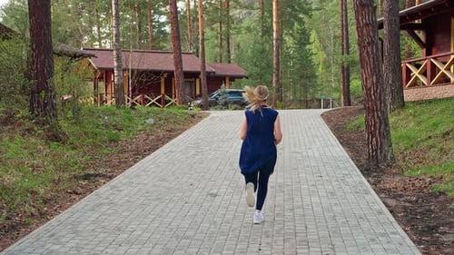 Young Woman Running Through the Woods