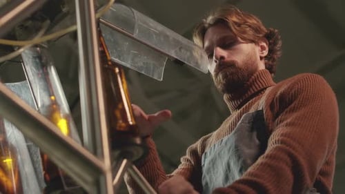 Factory Worker Inspects Automated Bottle Machine
