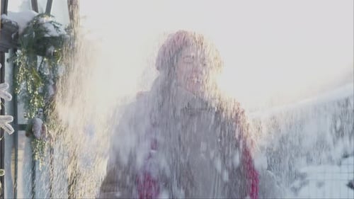 Cheerful Woman Enjoying Falling Snow in Winter