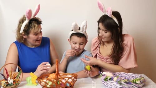 36. Mother, son and daughter are treated to an Easter chocolate egg. Celebrating Easter in the famil