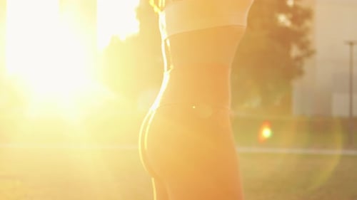Woman Stretching with Resistance Band in Golden Park Light