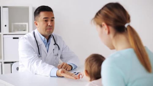 Doctor consulting with mother and infant in office