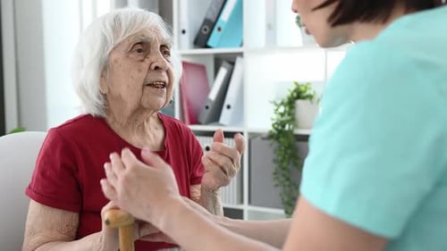 Mature Woman Talking with Healthcare Professional Indoors