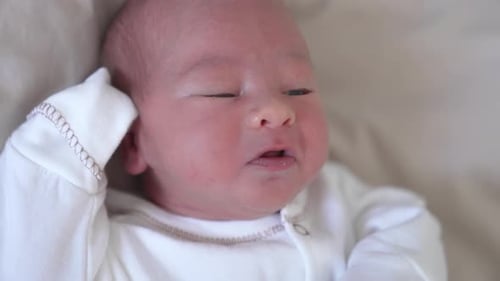 Close Up of Newborn Infant Lying on Blanket