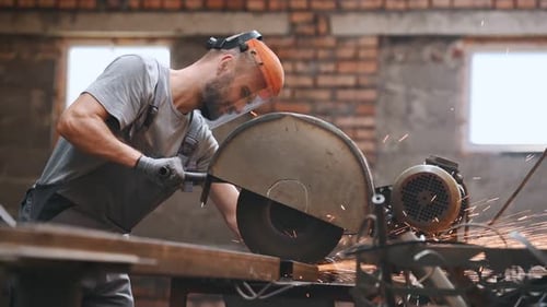 worker cuts metal on a circle and a circular saw. steel pipes and cylindrical blanks for welding.