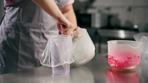 Close Up Female Baker in Professional Kitchen Transfers Cream Paste Into a Pastry Bag