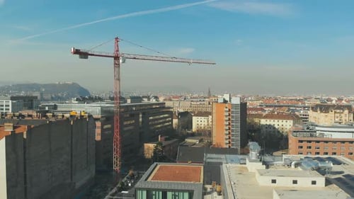 Aerial shot as a crane working on a construction, bird eye view over a city in Europe