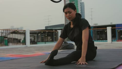 Woman Stretching on Rooftop Practicing Yoga with Wheel