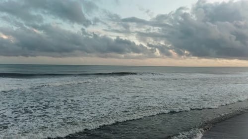 Waves in the Ocean at Sunset in Cloudy Weather