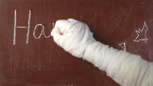 Mummy Writes Happy Halloween on Chalkboard