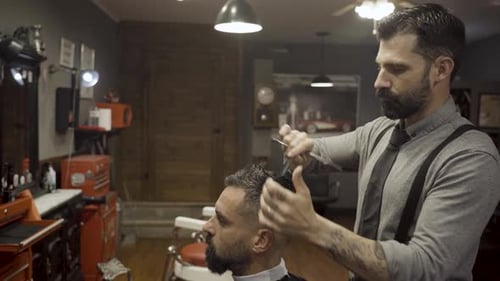 Barber Cuts The Hair Of The Client With Scissors - close up