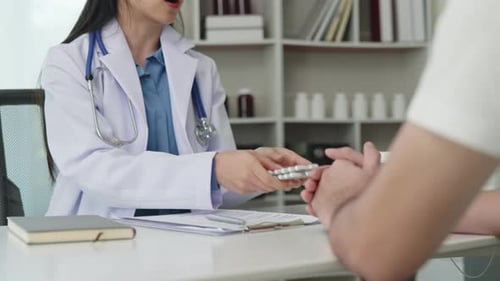 Doctor Consulting With Patient in Clinic Office