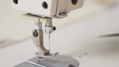 Close Up Of Designer Fixing Thread On Electric Sewing Machine