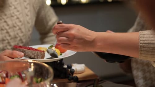 Woman Serving Food at Festive Dinner Table