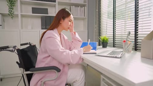 Frustrated Asian businesswoman in wheelchair work in office workplace.
