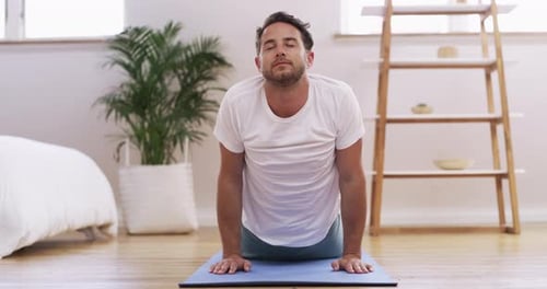 Man Performs Yoga Poses on Mat in Bedroom