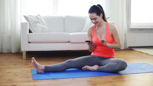 Woman Stretching on Yoga Mat Listens to Music