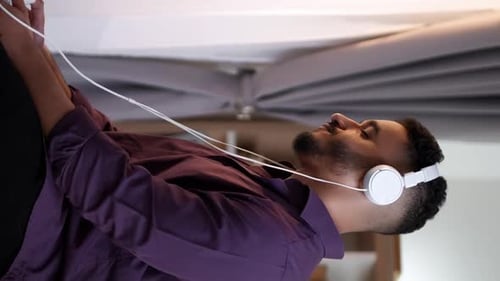 Young Man Relaxing and Listening to Music Indoors