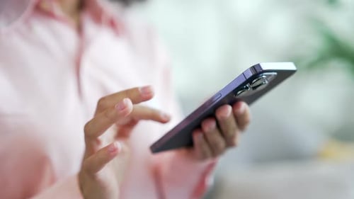 Close up of female hands holding a smartphone. Young african american female using mobile phone