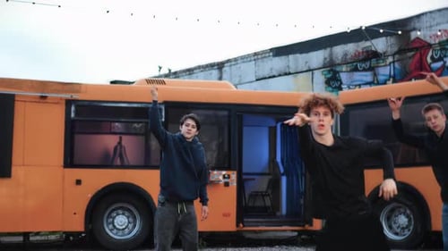 Youthful Group Dancing in Front of a City Bus