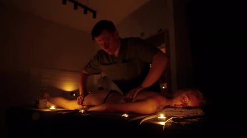 A Male Masseur Gives a Massage to a Girl By Candlelight A Warm and Relaxing Atmosphere in the Spa