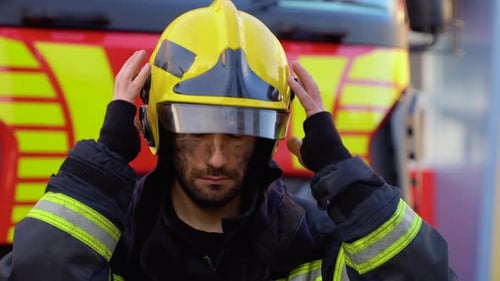 Serious Firefighter Removes Yellow Protective Helmet