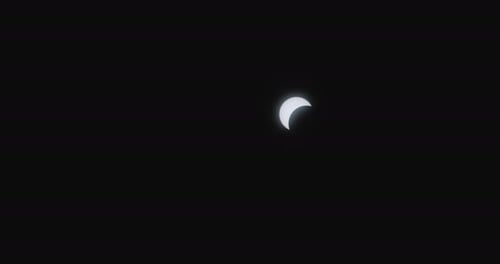 A solar eclipse with the moon partially covering the sun in a dark sky