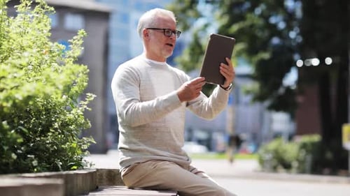 Man with Tablet Computer Sitting on Park Bench