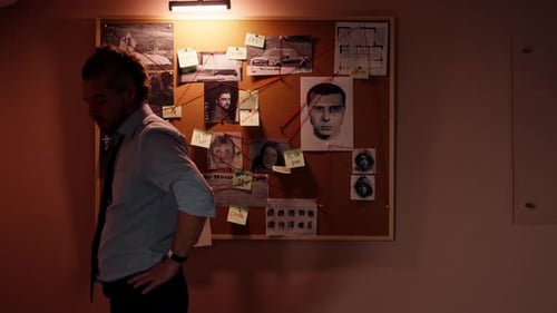 Detective's Office Middleaged Investigator in Shirt and Tie Studies Evidence in Search of the