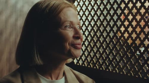 Senior Woman Having Conversation with Priest Sitting in Confessional