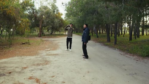 Un père âgé observe des oiseaux à l'aide de jumelles avec son fils dans une forêt de montagne