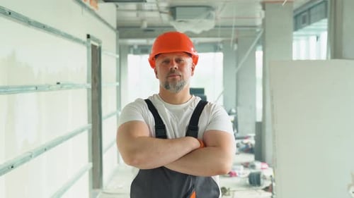 Portrait of a Positive 50s Builder in Safety Helmet on the Construction Site